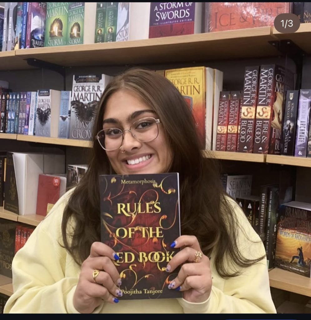 Pooja Tanjore holding Rules of the Red Book in a bookstore
